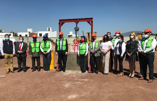 Personal de construcción en sitio industrial con equipo de protección.