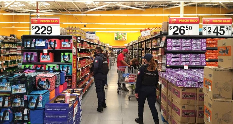 Policía en supermercado controlando vigilancia y seguridad en tienda.