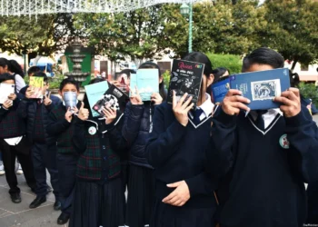 Libros en manos de estudiantes en una fila en la escuela.