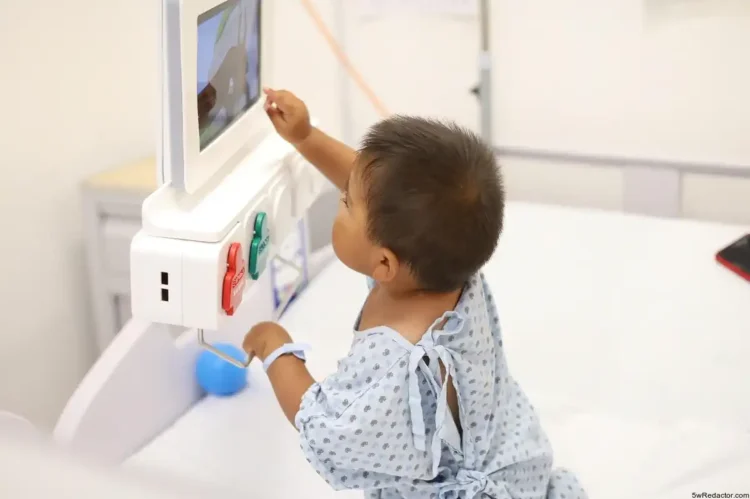 Niño en hospital usando monitor médico para diagnóstico.