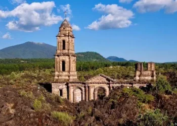Ruinas históricas en México con paisaje de montaña y vegetación exuberante.