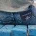 1. Pasaporte en el bolsillo trasero de jeans en banco de madera azul.