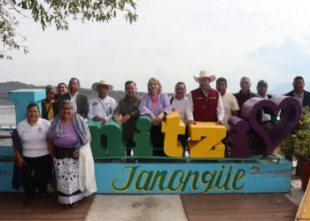 Personas en la plaza tourism en Tonquie, Chiapas, México, con letras decorativas y paisaje natural de fondo.