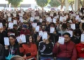 Aprendizaje masivo de estudiantes en un evento al aire libre con certificados en mano.
