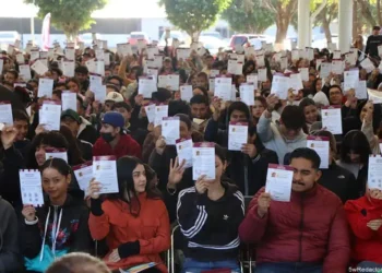 Aprendizaje masivo de estudiantes en un evento al aire libre con certificados en mano.