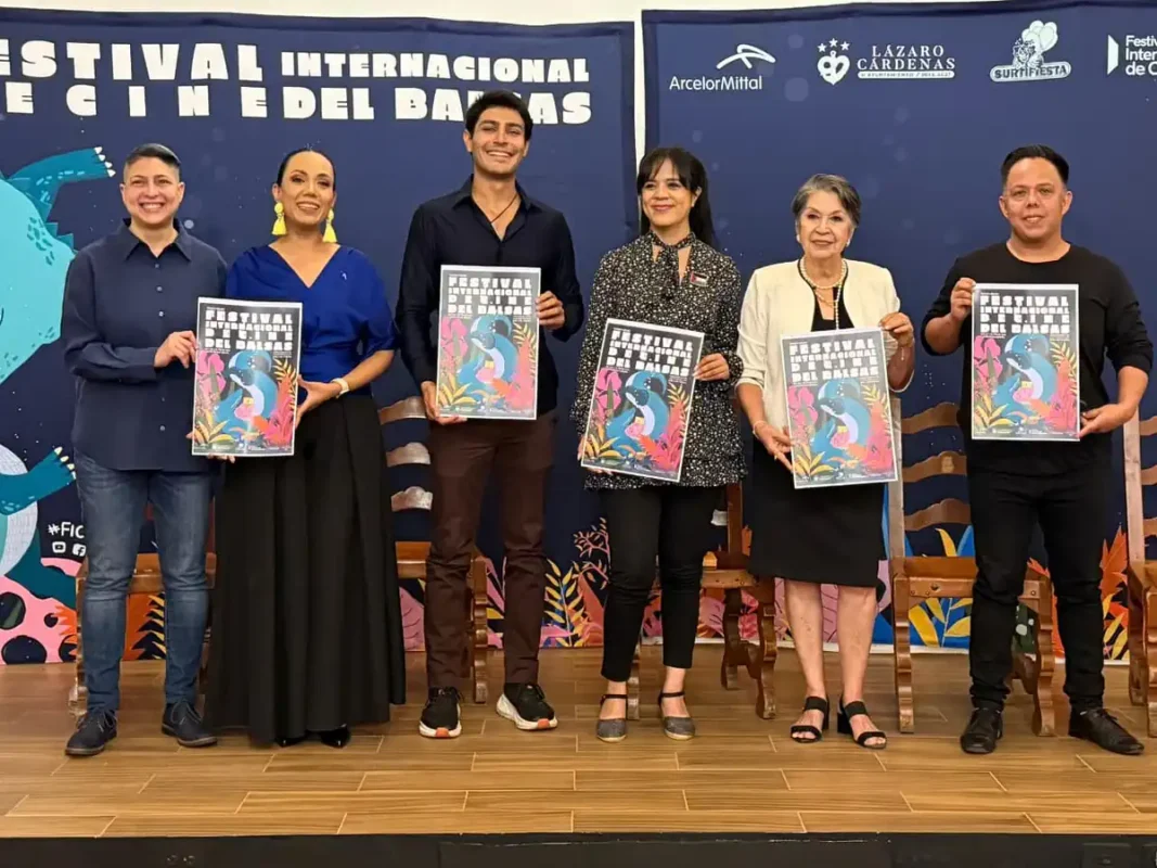Boca de la imagen con personas sosteniendo carteles en un evento cultural internacional.