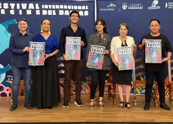 Boca de la imagen con personas sosteniendo carteles en un evento cultural internacional.