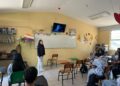 Aprendizaje en aula con estudiante presentando frente a clase en salón escolar.
