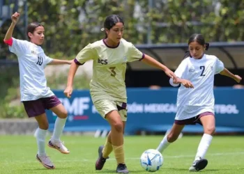 Jugadoras de fútbol femenino en acción durante un partido en el campo.