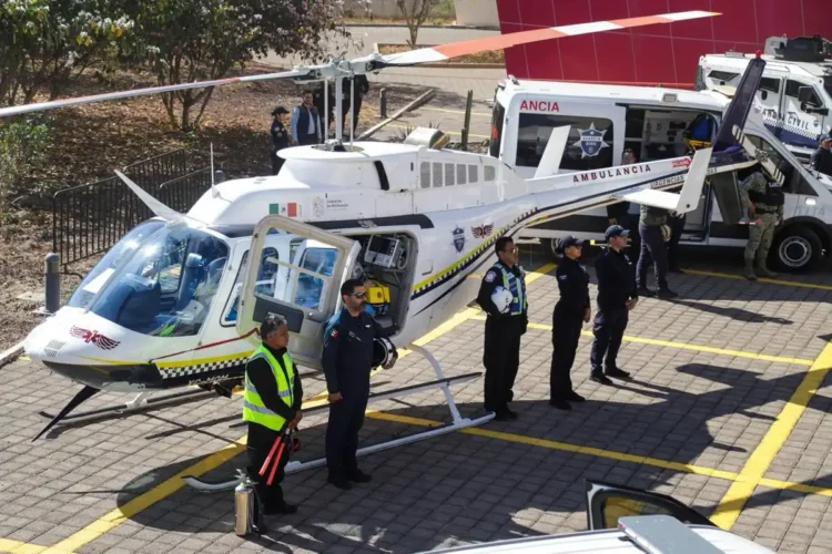Helicóptero de emergencia con personal de rescate y ambulancia en escena.
