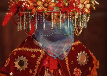 Persona con vestimenta tradicional y corona de flores en celebración cultural en México.