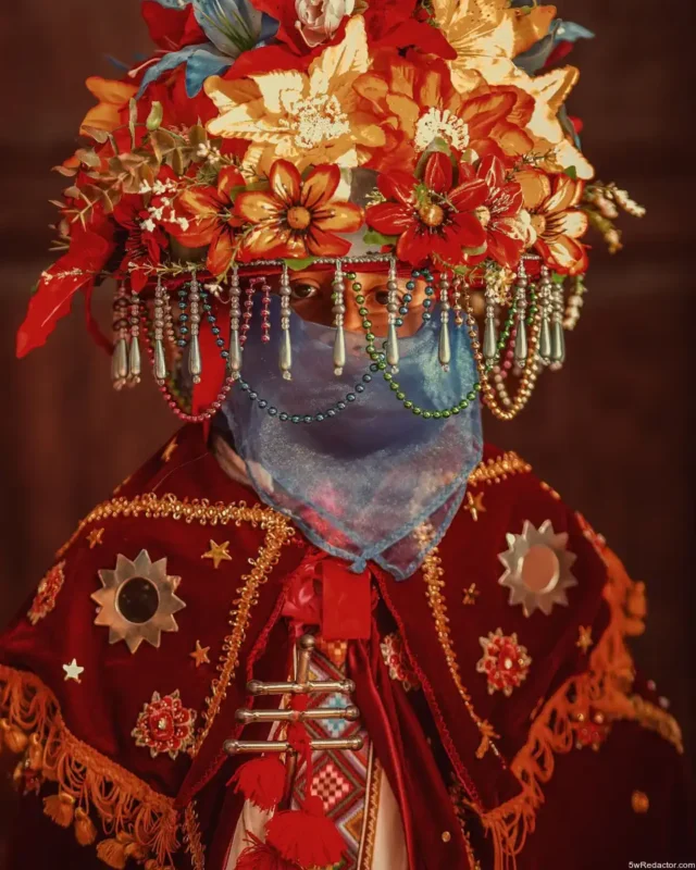 Persona con vestimenta tradicional y corona de flores en celebración cultural en México.