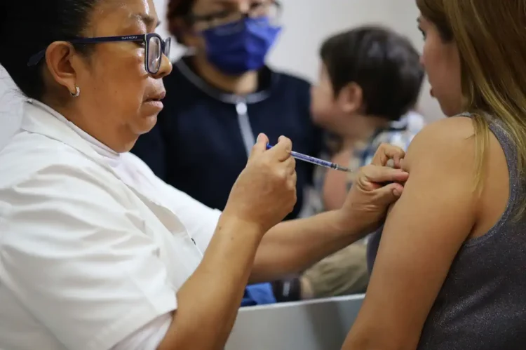 Vacunación contra COVID-19 en un centro de salud con personal médico y pacientes presentes.
